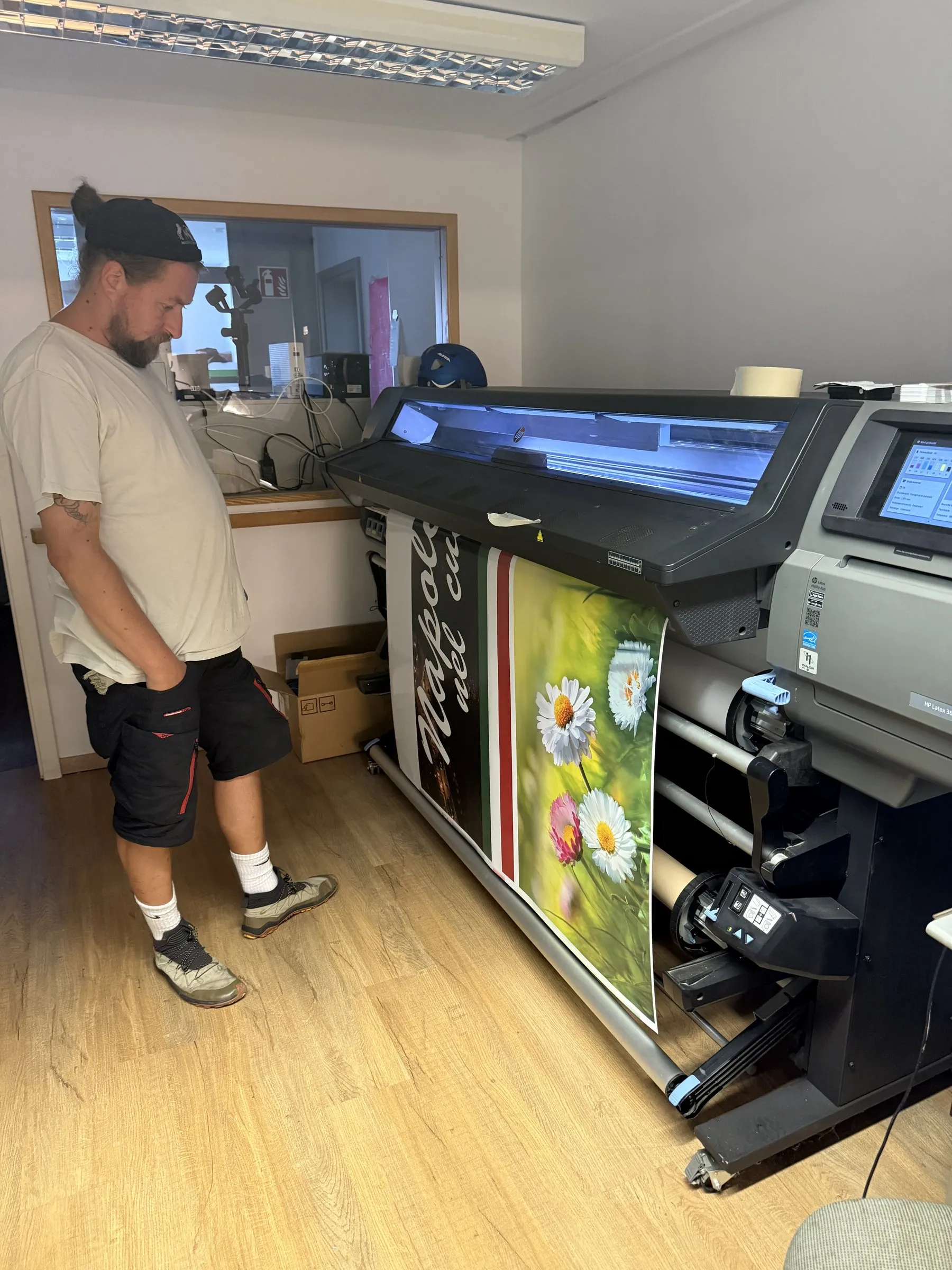 Mitarbeiter am Großformatdrucker in der Werkstatt von HD Vision in Wolfsburg