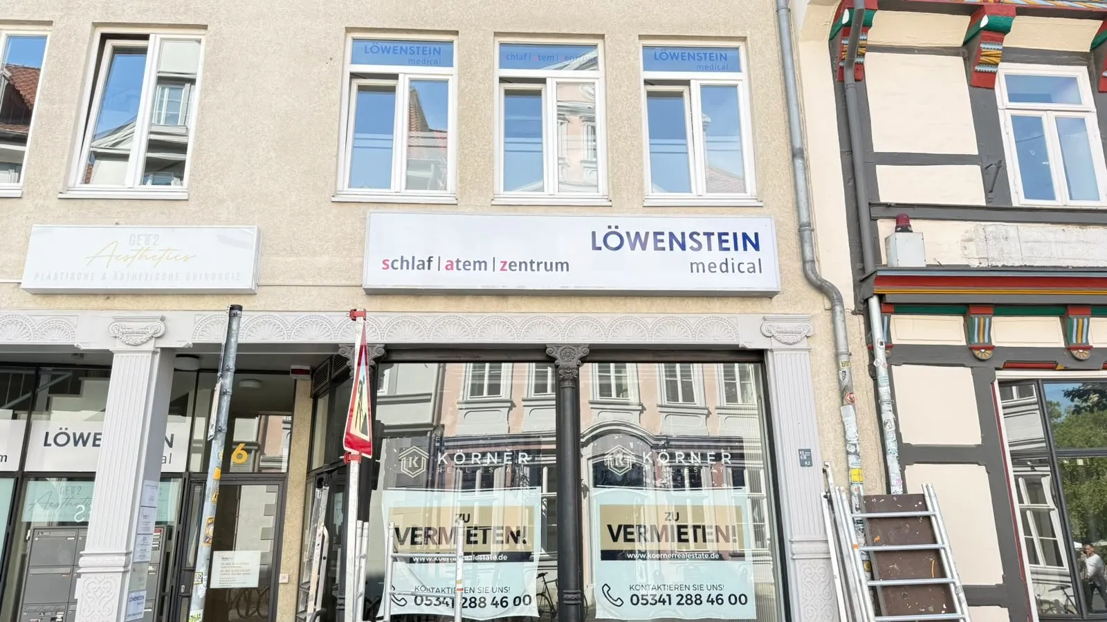 Fassadenschild und Fensterbeschriftung einer Praxis in der Altstadt