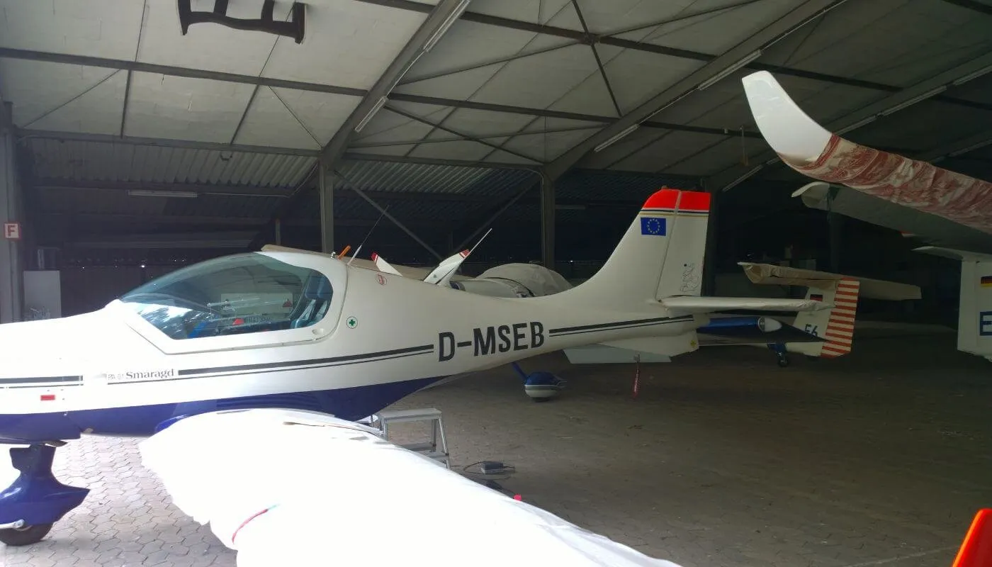 Beschriftetes Ultraleichtflugzeug im Hangar, Seitenansicht
