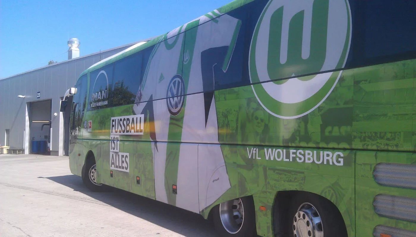 Komplett grün folierter Mannschaftsbus des VfL Wolfsburg