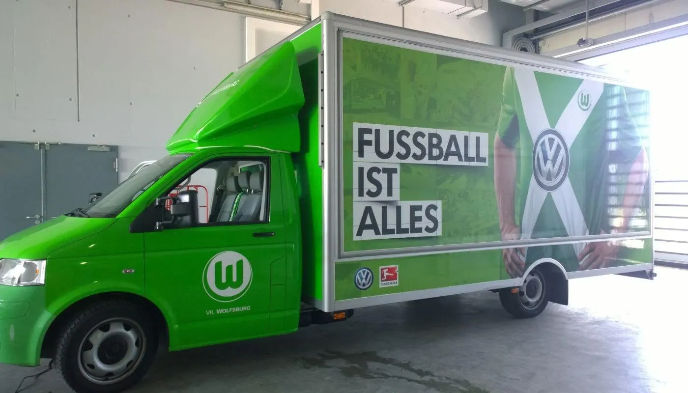 Grün folierter Koffer-Lkw im Design des VfL Wolfsburg