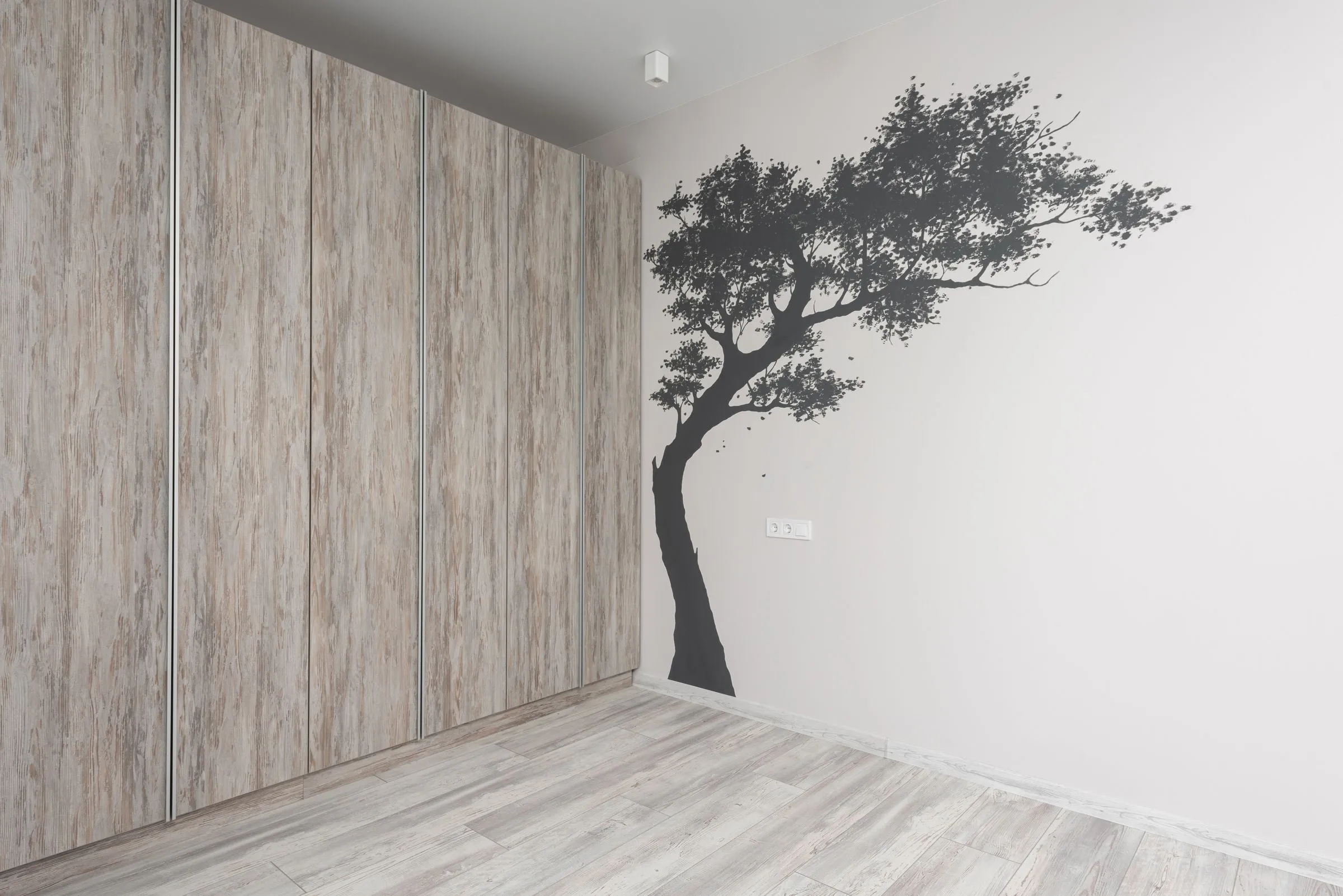 Graue Baum-Silhouette als Wandtattoo an einer weißen Wand