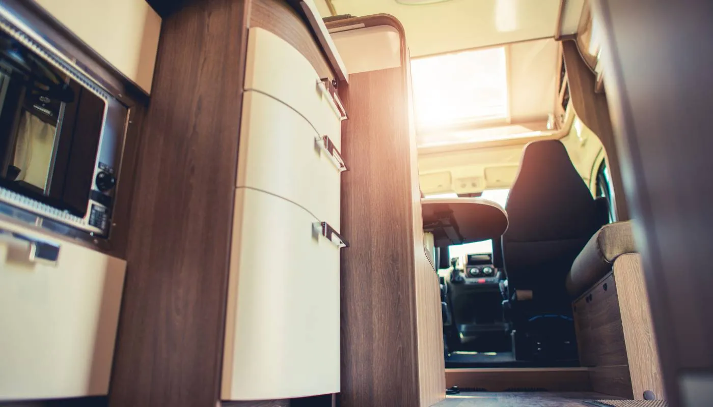 Innenraum eines Wohnmobils mit Schubladen in Creme und Möbeln in Holzoptik